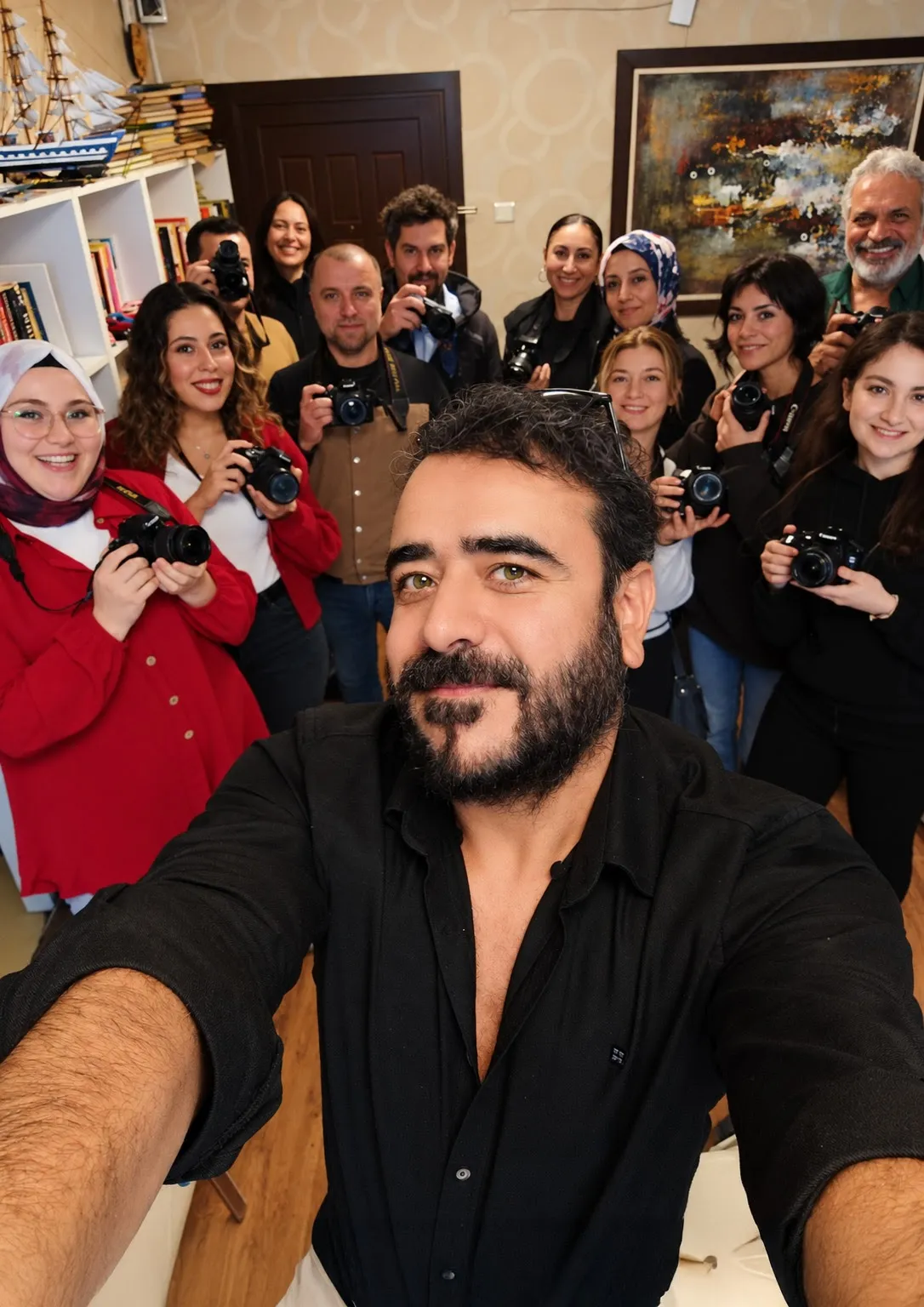 Ankara fotoğrafçılık kursunda eğitmen Hakan Kılıç ve öğrencilerin fotoğraf makineleriyle açık havada çekilmiş grup fotoğrafı.